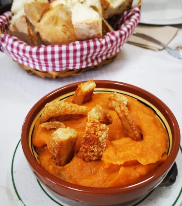 Plato de patatas revolconas tradicionales con torreznos crujientes en el restaurante Venta la Colilla, Ávila.