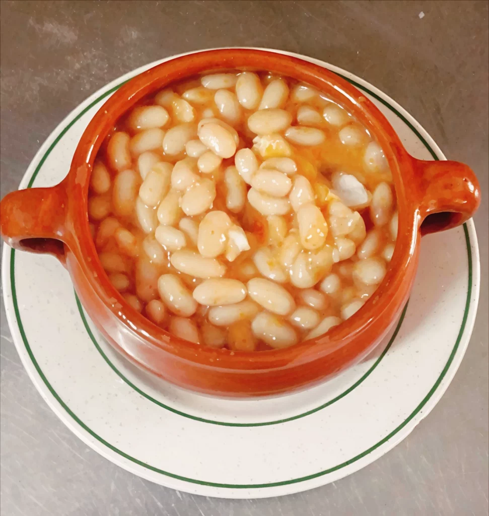 Judías blancas servidas en cuenco de barro en Venta La Colilla