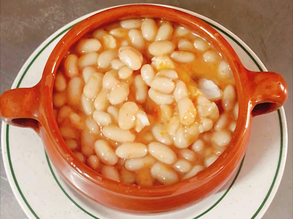 Judías blancas servidas en cuenco de barro en Venta La Colilla