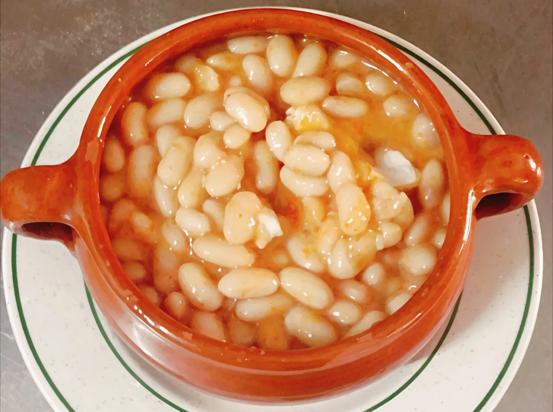 Judías blancas servidas en cuenco de barro en Venta La Colilla