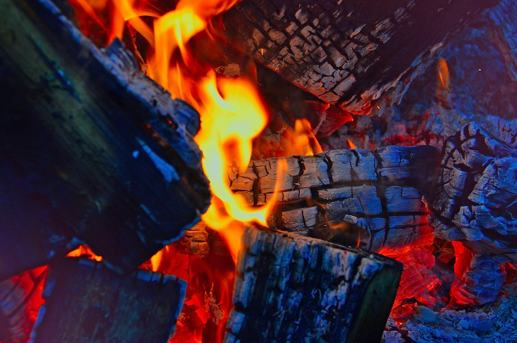 Fuego de leña tradicional encendido, representando el método de cocina artesanal para platos de Ávila.