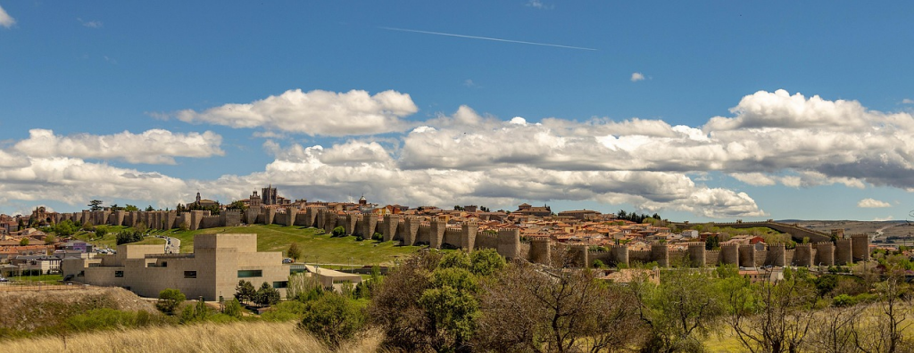 Perspectiva exterior de las murallas de Ávila desde el paseo perimetral, destacando su imponente altura y conservación.
